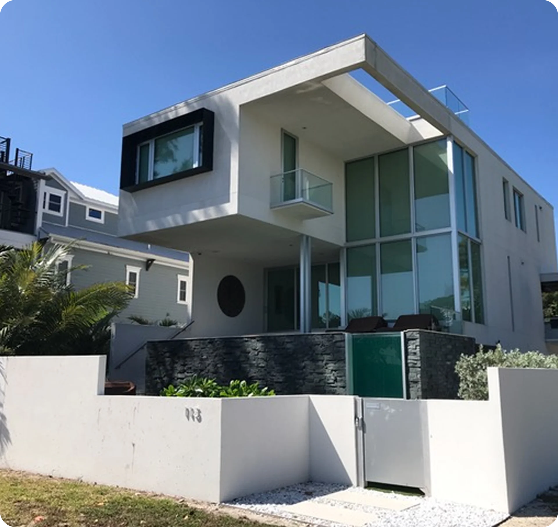 Modern two-story house with large windows.