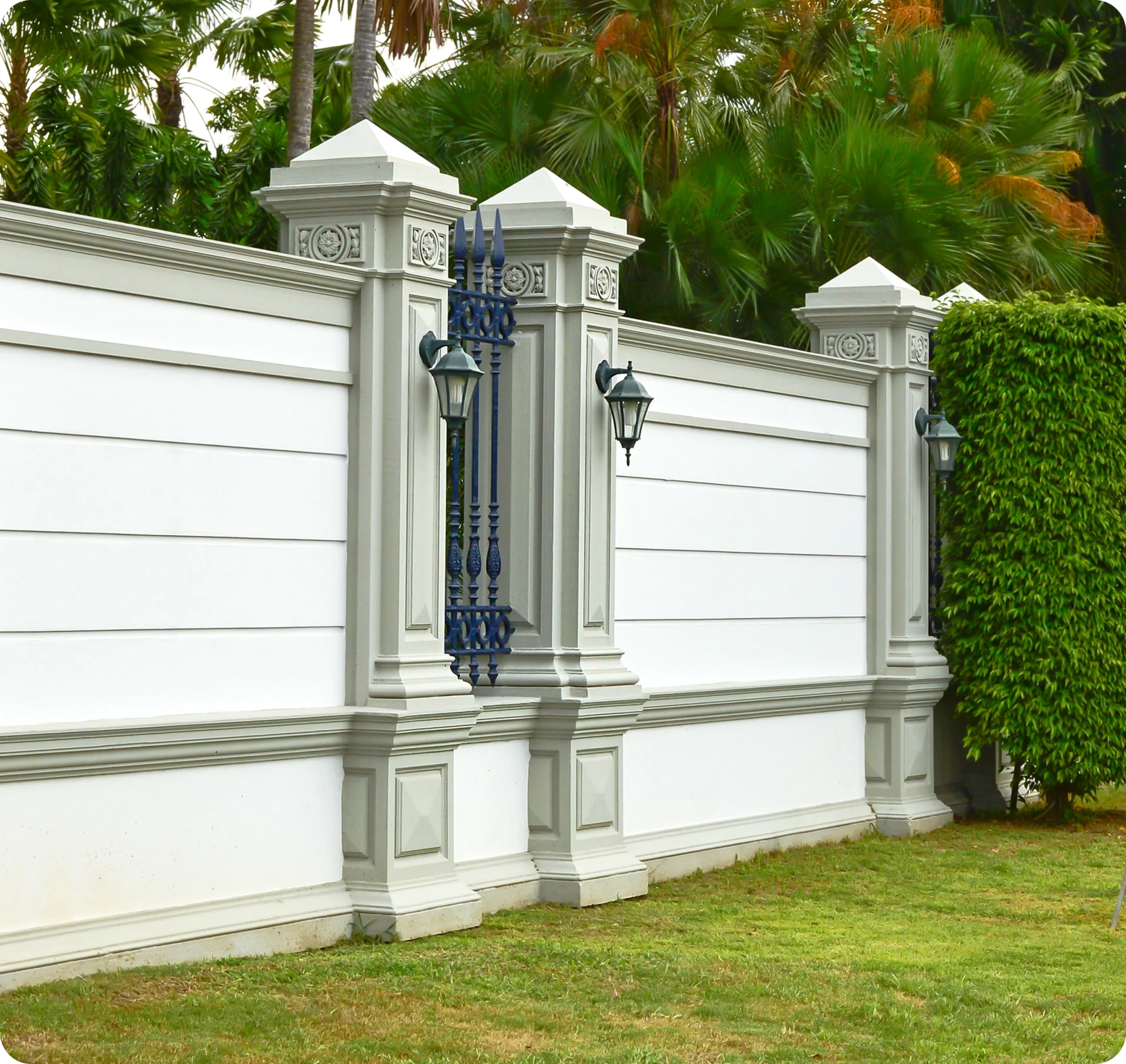Decorative white wall with lanterns and greenery.